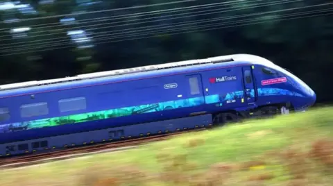 A blue Hull train speeds along the track - the photo is blurred.