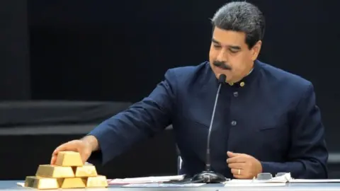 Venezuela"s President Nicolas Maduro touches a gold bar as he speaks during a meeting with the ministers responsible for the economic sector at Miraflores Palace in Caracas, Venezuela March 22, 2018.