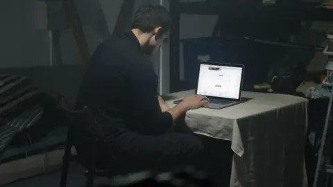 Getty Images Man on a laptop in a dark room