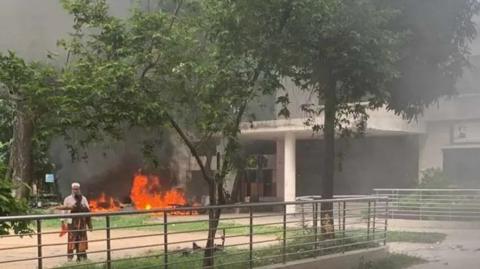 A fire burns outside BTV headquarters in Bangladesh