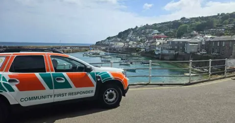 South Western Ambulance Service Trust A parked community first responder vehicle with a seaside town in the background.