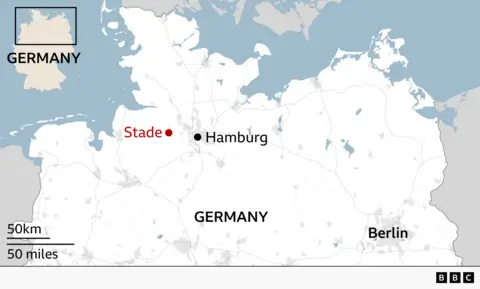 Map of northern Germany highlighting the location of Stade relative to major cities. A red dot and label mark Stade to the west of Hamburg, which is shown with a black dot near the centre of the map. Berlin is labelled in the southeast. Surrounding countries and coastal outlines are faintly visible, with light grey roads and terrain details. An inset map in the top left shows Germany’s outline with the highlighted northern region. A scale in the bottom left indicates approximately 50 km / 50 miles, and a small BBC logo appears in the bottom right.