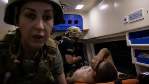 Jess Daly Anna and Iryna, two volunteer Hospitaller medics evacuating a wounded soldier and surgeon who stepped on a landmine. Zaporizhia region