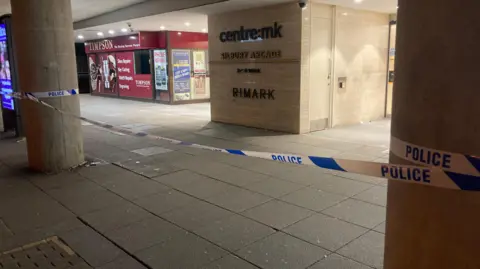 Justin Dealey/BBC Police tape outside the MK:Centre at night.