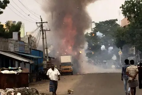 AFP via Getty Images Residents walk near an exploding fireworks factory in Sivakasi in the southern India state of Tamil Nadu