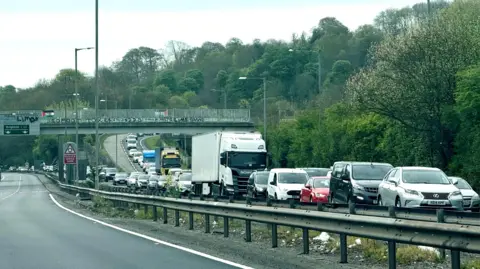 Eddie Mitchell A dual carriageway with queuing cars on it. 