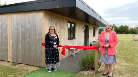 Teachers cut the ribbon to mark the opening of a wellbeing cabin