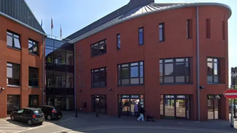 Google Brick building with many small windows and semi-circular façade