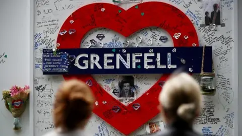 Reuters Women look at a hoarding covered in messages of condolence