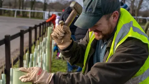 Creating Nature's Corridors A man planting trees as part of a rewilding project with Creating Nature's Corridors