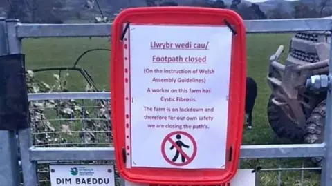 Elliw Angharad A sign warning people against walking on the paths