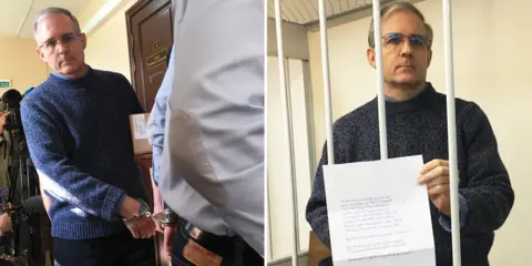 Paul Whelan arrives handcuffed and holds a personal statement up in court