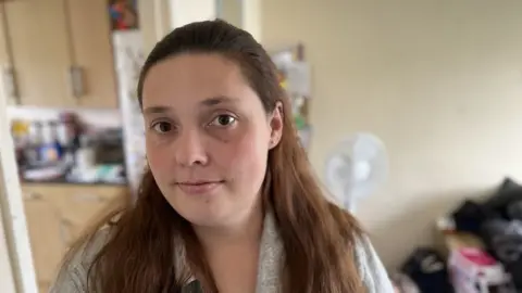 A woman standing in her house