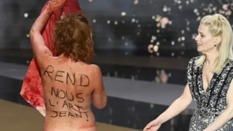 EPA Corinne Masiero strips naked during a protest at the Cesar Awards