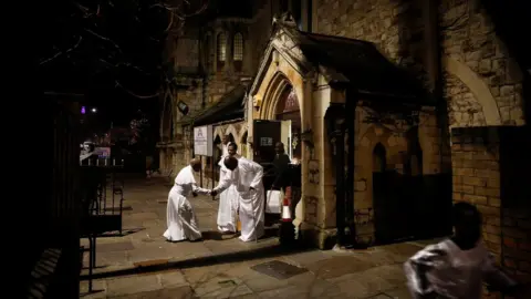 Simon Dawson / Reuters Worshippers greet following a night-time Christmas Eve service at the Celestial Church of Christ in Elephant and Castle