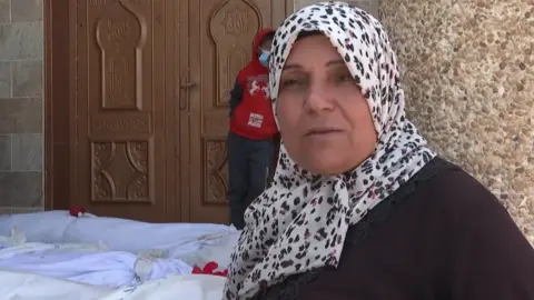 BBC Kareema Elras stands next to bodies exhumed from Nasser hospital, in Khan Younis, southern Gaza (24 April 2024)