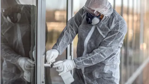 Getty Images Cleaner wearing a face mask