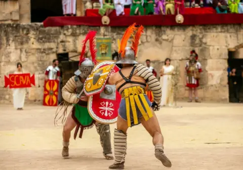 YASSINE GAIDI/GETTY IMAGES Tunisians gather at the Amphitheater of El Djem for the 'Thysdrus Rome Days' Festival.