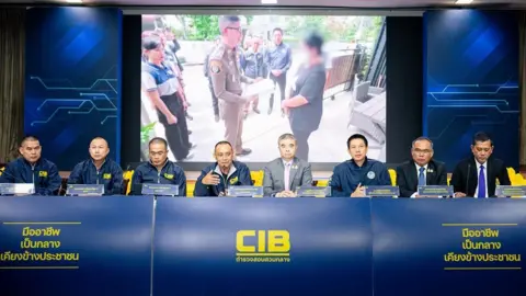 Thai News Pix Police officers sitting in a row behind a long table