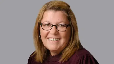 Louth and Horncastle Labour Claire Arnold, with long light hair, black-rimmed glasses and wearing a dark purple top