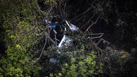 Shutterstock An image of the wreckage of a cable car in thick woodland after at crashed.