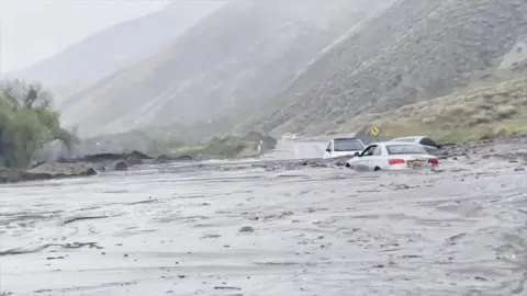 Multiple cars are stuck in the mud due to storm.