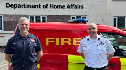 Richard Little and Mark Kermode in front of a fire van outside the Department of Home Affairs in Tromode