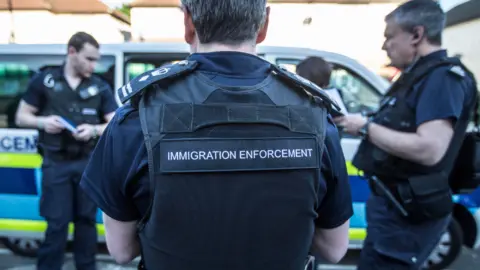 Immigration enforcement officers listen to a brief his on the occupants of the houses they are about to raid for illegal immigrants, on May 21, 2015 in London, England. 