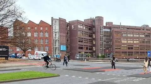 A cyclist using a designated path on a stretch of road near Leeds Sixth Form College. Pedestrians are also crossing the busy corridor.