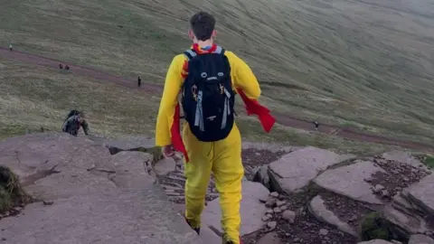 Luke Woodward Luke trekking across a mountain in his costume.