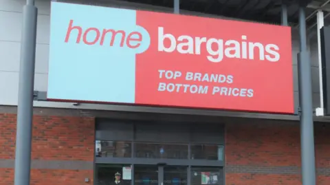 PA Media The blue and red signage of a Home Bargains store