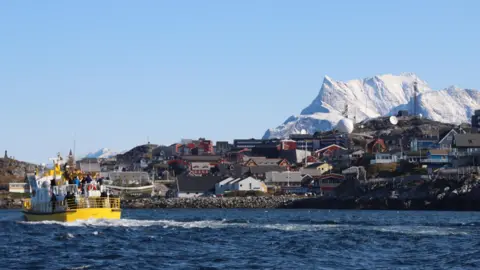 Een gele boot vlak voor de kust van de Groenlandse hoofdstad Nuuk.