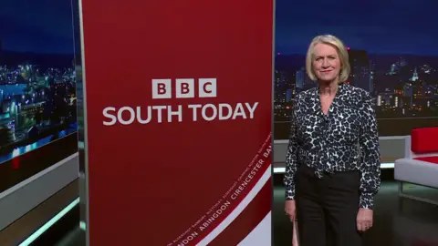 Sally Taylor standing next to a red South Today banner in the TV studio