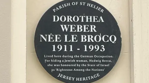 A Jersey Heritage wall plaque remembering Dorothea Webber who loves from 1911 to 1993 who hid Jewish woman Hedwig Bercu in her home and was honoured by the State Of Israel
