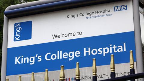 A sign for King's College Hospital, featuring an NHS logo