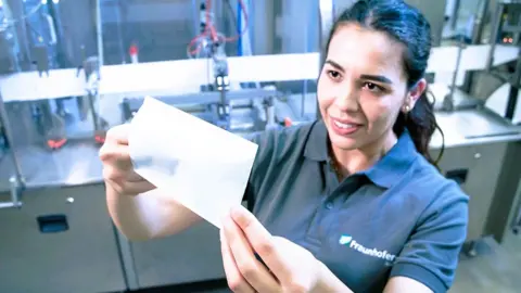 Fraunhofer A female Fraunhofer worker holds up some paper which has been sealed using a laser sealing process.