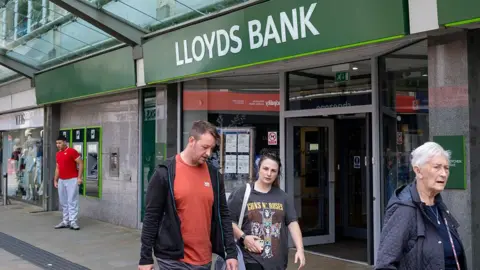 Getty Images People walking outside a branch of Lloyds Bank in Swansea, Wales