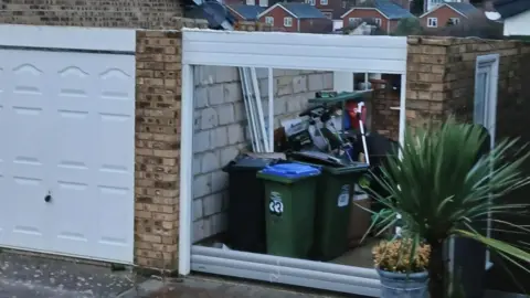 Terry Purcell A garage with both its roof and front door blown off.