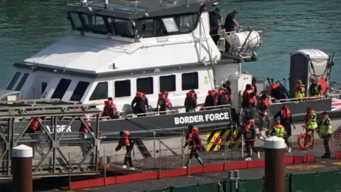 PA Media A group of people thought to be migrants are brought in to the Border Force compound in Dover, Kent. 