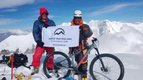 Neil Laughton and his Nepali climbing partner Sirdar Nima Kanchha Sherpa at the summit of a Himalayan mountain.