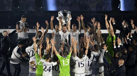Real Madrid football team celebrate winning the Champions League by putting their arms in the air
