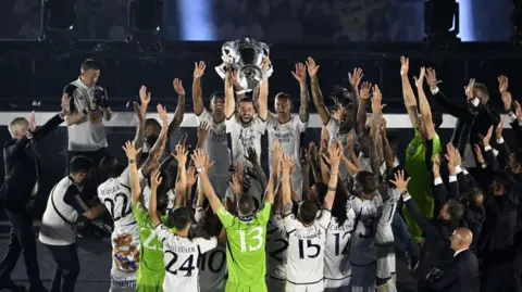 Getty Real Madrid football team celebrate winning the Champions League by putting their arms in the air