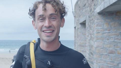 Martin Marescaux smiling at the camera. He has wet hair and is wearing a wetsuit.