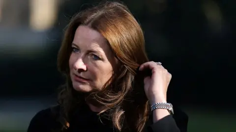 Education Secretary Gillian Keegan touches her hair during an interview