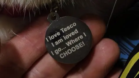 Tyler Petrie Photo of Frodo's collar tag, which reads "I love Tesco, I am loved, I go... Where I CHOOSE!"