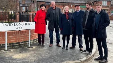 BBC Family and friends next to the David Longhurst Way street sign, including his sisters Jayne (far left) and Ann (third from left), as well as his best friend John Salisbury (in between Jayne and Ann) 