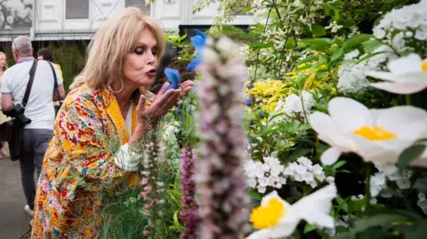 PA Media Dame Joanna Lumley poses at the Burncoose Nurseries stall at the RHS Chelsea Flower Show