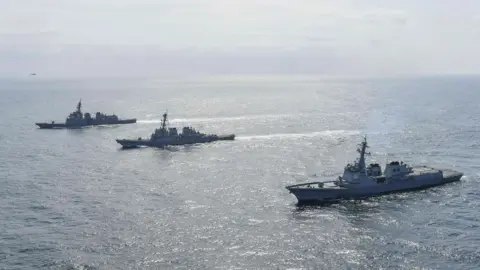 Getty Images South Korean Navy's destroyer Yulgok Yi I (R), U.S. Navy's USS Benfold (C) and Japan Maritime Self-Defense Force's JS Atago (L) sail in formation during a joint naval exercise in international waters on April 17, 2023