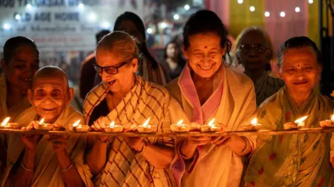 Getty Images Elderly women at Pramod Talukdar Memorial Old Age Home light Diya oil lamps as they celebrate Diwali in Guwahati, India, on November 1, 2024.