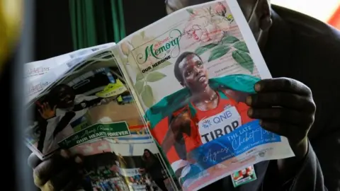 Reuters A mourner reads the eulogy program during the funeral service of long-distance runner Agnes Tirop